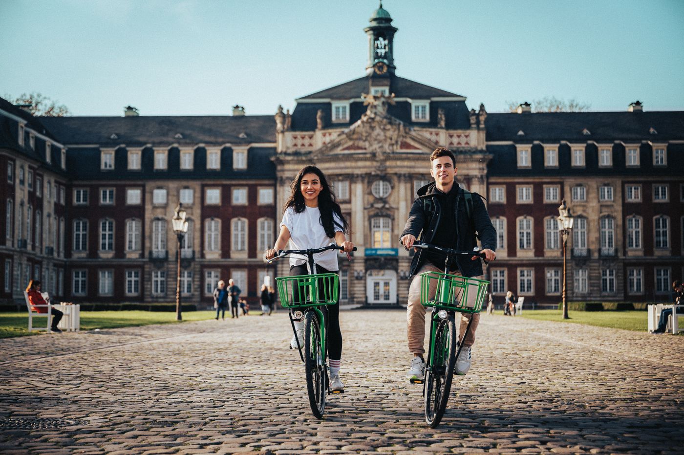 Twee studenten fietsen over een Europese campus